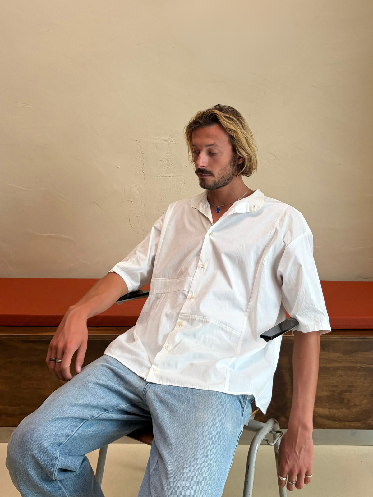 Model seated wearing The Blank Canvas One white upcycled shirt by Kazuki