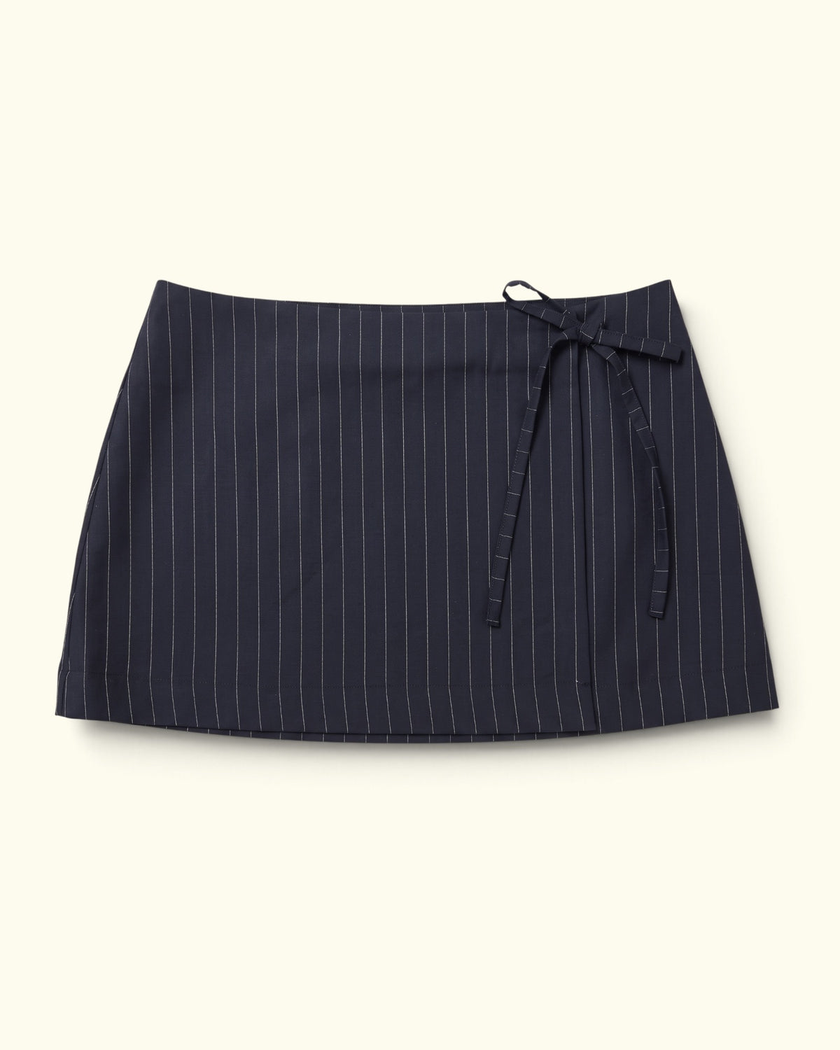 Pinstripe Wrap Skirt black wool low-rise mini skirt by Kazuki, front view with side tie
