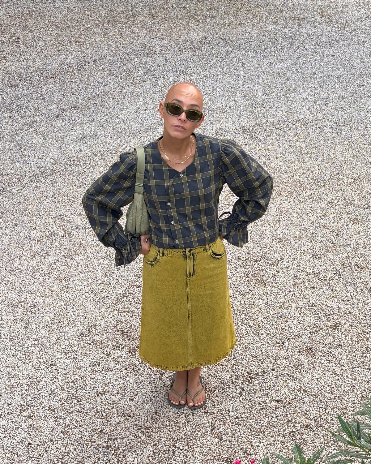 Model wearing the Tartan Dolly Long Sleeve grey and olive cotton blouse by Kazuki with a yellow denim long skirt